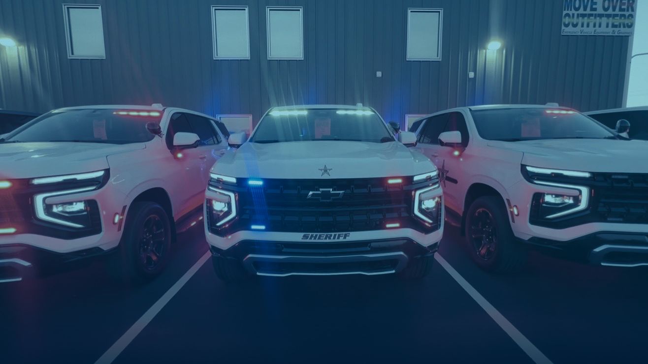 Three police SUVs inside the shop with emergency lighting activated