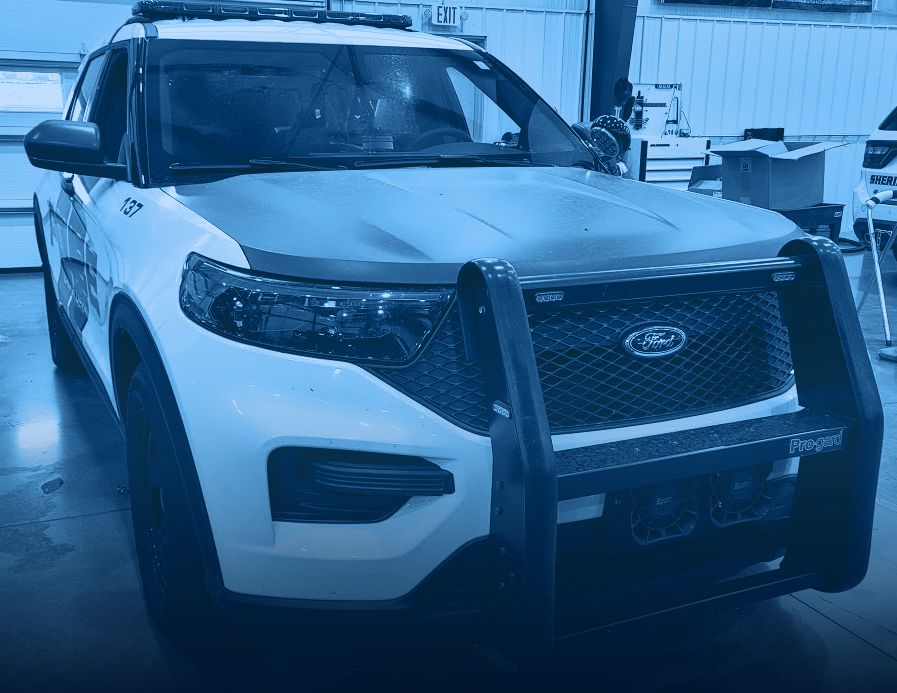 White police SUV with push bumper and emergency lighting